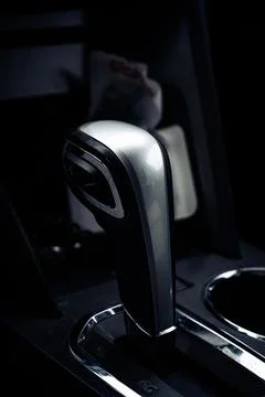 A modern car that is empty in the dark, with a silver shift button Stock Photos