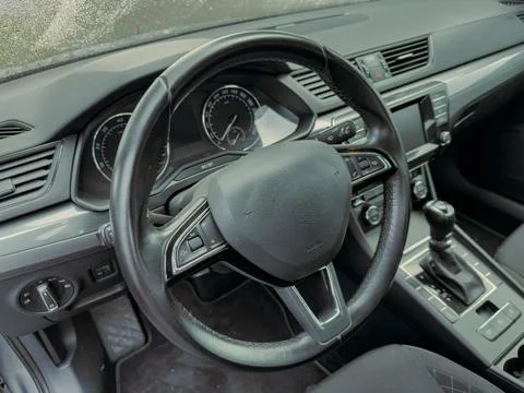 Modern car interior showcasing a sleek steering wheel and dashboard with va.. Stock Photos