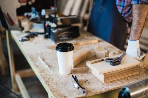 Modern carpentry work place with tablet, coffee, scissors and wooden pieces on Stock Photos