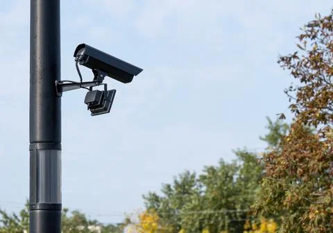 Modern CCTV security system on sky background Smart camera theft protection. Stock Photos