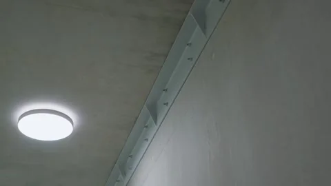 Modern ceiling light flush-mount LED fixture next to an industrial-style steel Stock Footage 331426737