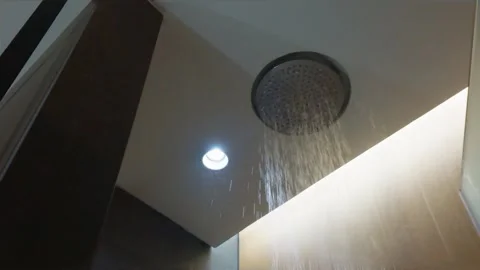 Modern ceiling mounted rain shower head with flowing water in luxury bathroom in 스톡 동영상 344092023