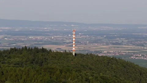 Modern Cell Tower Standing Tall on a Forested Hill Overlooking a Vast Rural Stock Footage 339357877