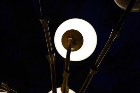 Modern chandelier with glowing spherical light bulbs against a dark background Stock Photos