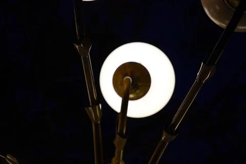 Modern chandelier with glowing spherical light bulbs against a dark background Stock Photos