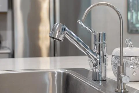 Modern Chrome Kitchen Faucet With Pull-Out Sprayer on Countertop Stock Photos