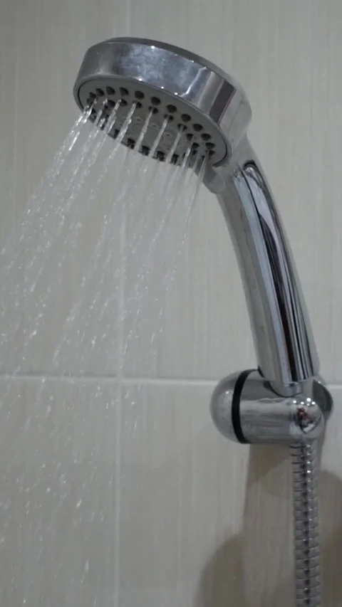 Modern chrome shower head mounted on tiled bathroom wall Stock Footage 346639696