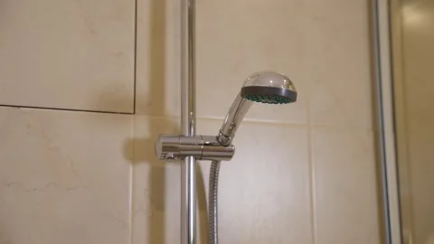 Modern chrome showerhead mounted on beige marble tile wall in bathroom Stock Footage 341404953