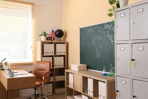 Modern classroom interior with chalkboard, student lockers, and teachers desk Stock Photos