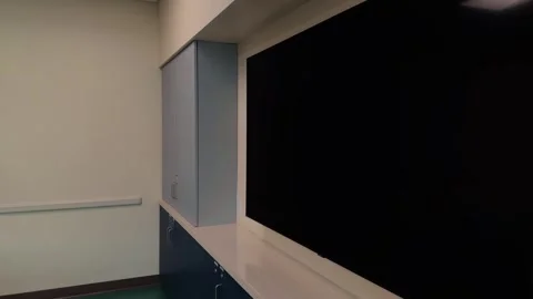 Modern classroom with whiteboard and wall clock in slow steady right to left pan Stock Footage 332637033