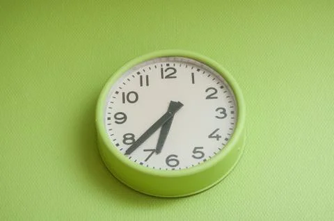 Modern clock on green wall Stock Photos
