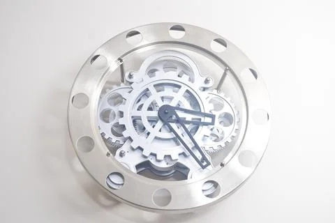 A modern clock hanging on the wall made of metal wheels Foto stock
