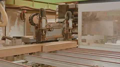 A modern CNC woodworking machine automatically grabs a large wooden beam for Stock Footage 327552335