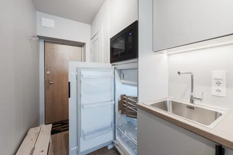 Modern Compact Kitchenette With Open Refrigerator, Stainless Sink And Micro.. Stock Photos