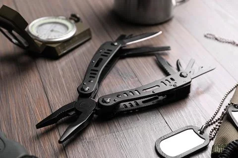 Modern compact portable multitool and accessories on wooden table Stock Photos