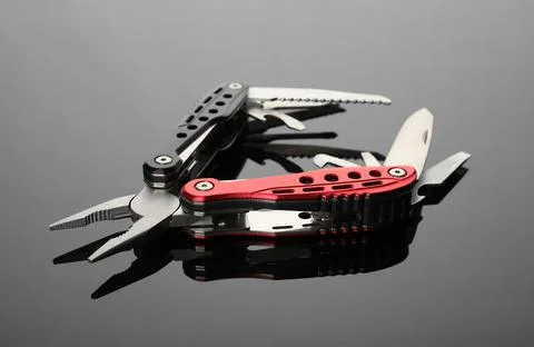 Modern compact portable multitool on grey table Stock Photos