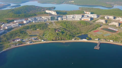 A modern complex of buildings on the shore of the bay surrounded by a large park Stock Footage 197002495