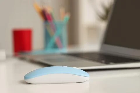 Modern computer mouse with laptop on table in office Stock Photos