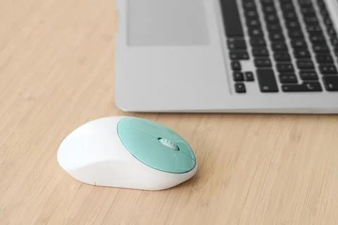 Modern computer mouse with laptop on table in office Stock Photos