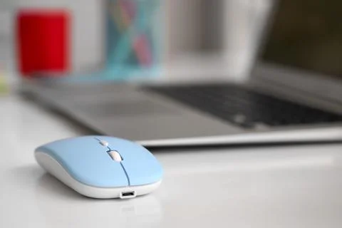 Modern computer mouse with laptop on table in office Stock Photos