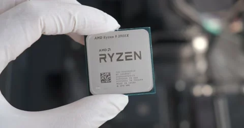 Modern computer processor AMD Ryzen 9 3900X CPU held with two gloved fingers Stock Footage 139421327
