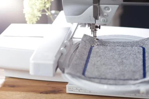 Modern computerised sewing machine with embroidery unit in bright light stitc Stock Photos