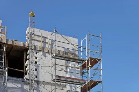 Modern construction forests for workers are leaning against the facade of a h Stock Photos