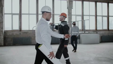 Modern construction site. Builders in helmets and overalls do their job Stock Footage 130775073