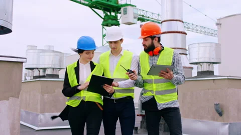 Modern construction site on the top of building young specialists walking Stock Footage 138202550