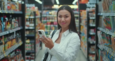 Modern consumer experience young millennial woman standing amidst well-stocked Stock Footage 312503413