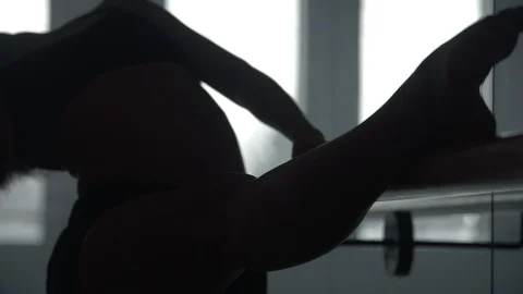 Modern contemporary dancer using dance studio hand rail to warm up Stock Footage 104269260