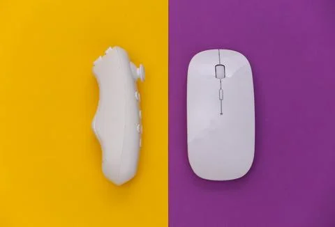 Modern controller and pc mouse on purple yellow background. Top view. Gadgets Stockfoto's