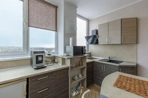 Modern Corner Kitchen Interior with Coffee Machine and City View Stock Photos