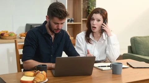 Modern couple collaborating over coffee in a cozy kitchen setting with a la.. Stock Footage 312981046