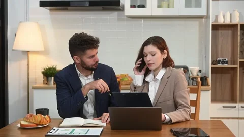 Modern couple collaborating over coffee in a cozy kitchen setting with a la.. Stock Footage 312981085