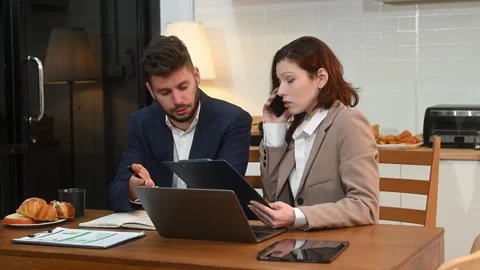 Modern couple collaborating over coffee in a cozy kitchen setting with a la.. Stock Footage 312981094