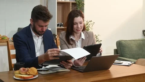 Modern couple collaborating over coffee in a cozy kitchen setting with a la.. Stock Footage 312981106