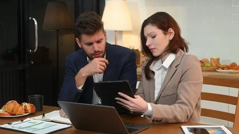 Modern couple collaborating over coffee in a cozy kitchen setting with a la.. Stock Footage 312981123