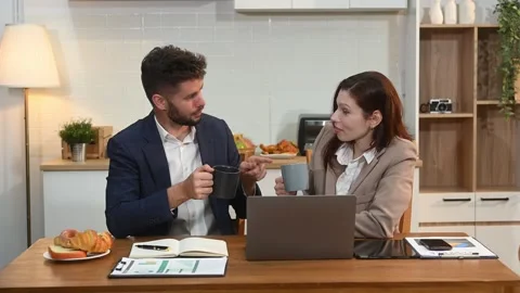Modern couple collaborating over coffee in a cozy kitchen setting with a la.. Stock Footage 312981130