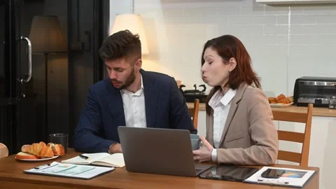 Modern couple collaborating over coffee in a cozy kitchen setting with a la.. Stock Footage 312981142