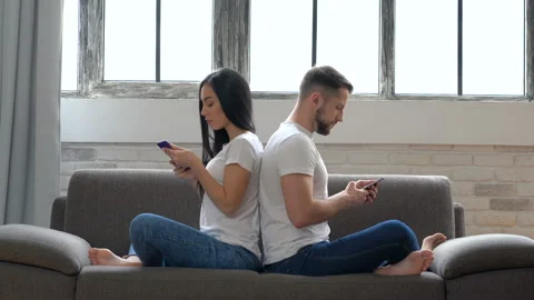 Modern couple sitting on the sofa back to back. No emotional, dont talking. Stock Footage 105350075