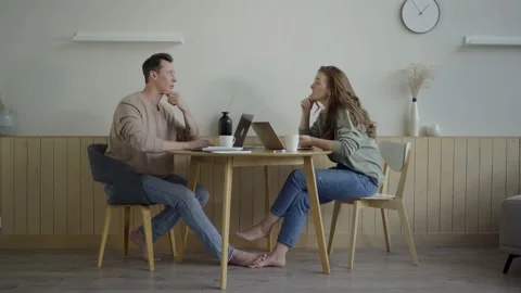 Modern couple working with laptops. Smart young couple discussing project at Stock Footage 139593595