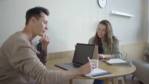 Modern couple working with laptops. Smart young couple discussing project at Stock Footage 139593686
