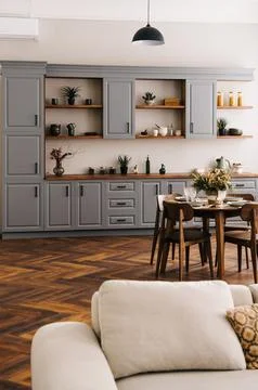 Modern cozy kitchen interior with a dining table and grey cabinets. Foto stock