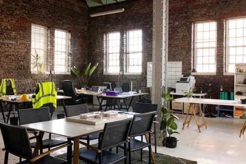 Modern creative office interior with exposed brick walls, desks and chairs Stock Photos