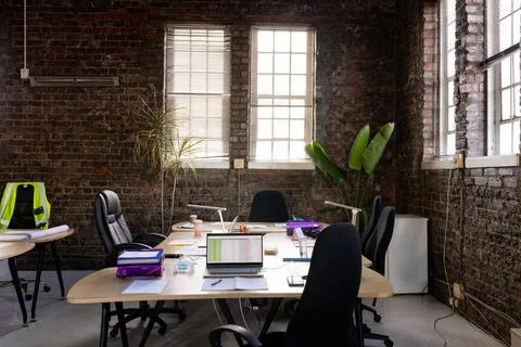 Modern creative office interior with exposed brick walls, desks and chairs 库存照片