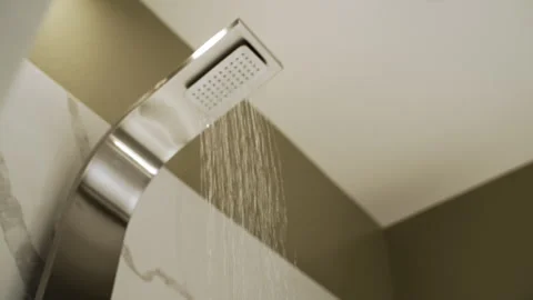 Modern Curved Rain Shower Flowing Over Marble Bathroom Wall - Rack Focus - UHD 動画素材 344082460