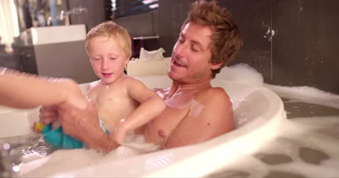 Modern Dad Plays with Son in Bubble Bath at Home Stock Footage 61501729