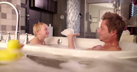 Modern Dad Plays with Son in Bubble Bath at Home Stock Footage 61501855