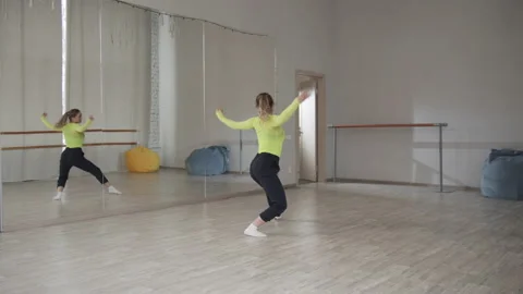 Modern dance with elements of acrobatics, a young girl jumps and dances in the Stock Footage 145526773